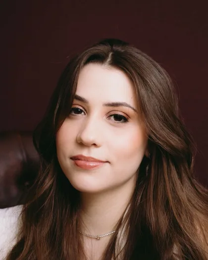 Dra. Drielle Bianchini Rodrigues em retrato de estúdio sobre fundo bordô.